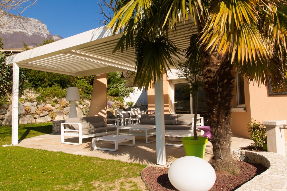 Photo de pergola bioclimatique nettoyée au-dessus d’un salon de jardin en automne