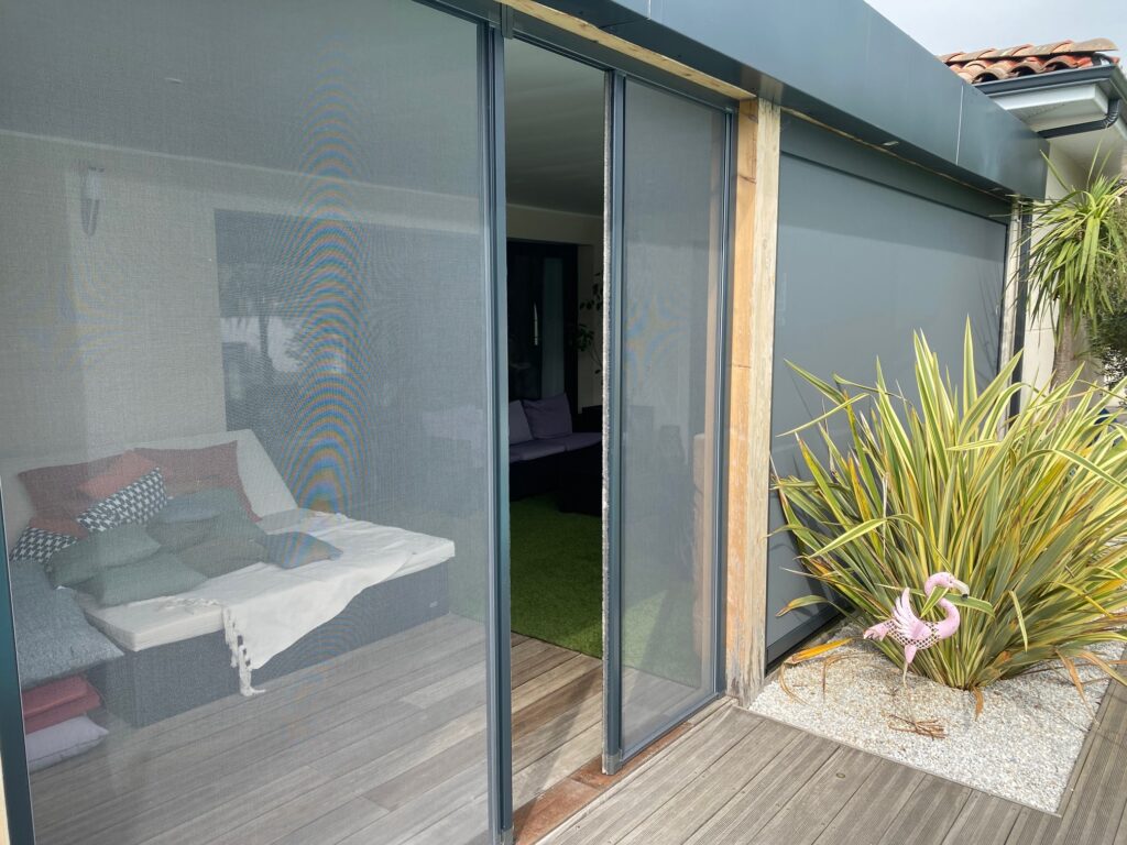 Moustiquaire latérale intégrée à une pergola pour profiter de la terrasse sans moustiques